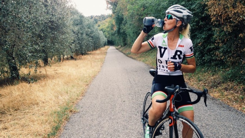 idratazione donna in bici e che beve dalla borraccia